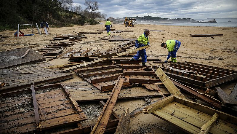 Operarios municipales recoge maderas acumuladas en la playa de los Peligros de Santander debido a los destrozos causados por el temporal marítimo.a los destrozos causados por el temporal marítimo.