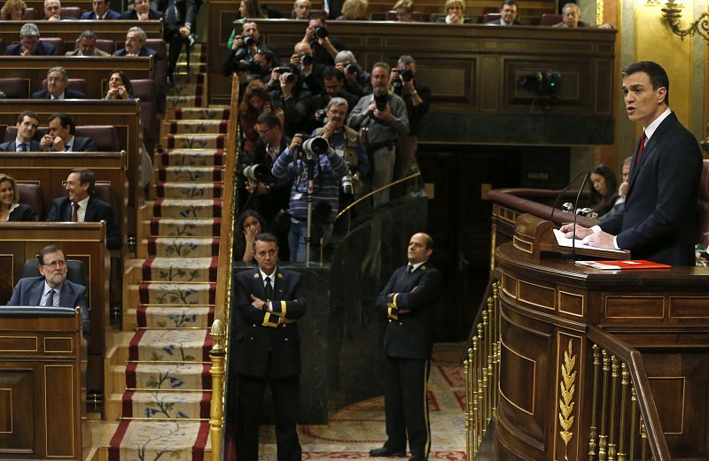 El presidente del Gobierno en funciones, Mariano Rajoy (i), escucha la intervención de Sánchez (d).