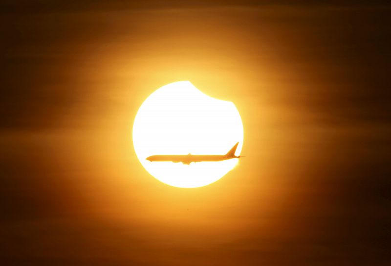 Un avión comercial pasa frente al sol eclipsado en Singapur.