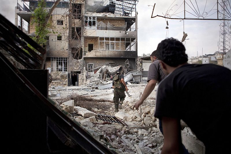 Rebeldes sirios corren e intentan evadir a los francotiradores del ejército leal al presidente sirio, Bachar Al Asad en Alepo, en octubre de 2012.