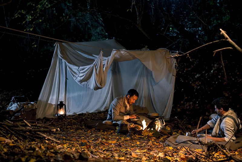 Miguel y Julián hablan en la tienda de campaña cuando llega la noche.