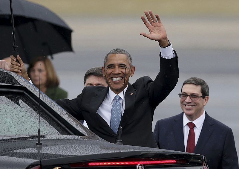 Obama saluda tras aterrizar en el aeropuerto de La Habana. A su lado el canciller cubano, Bruno Rodríguez.