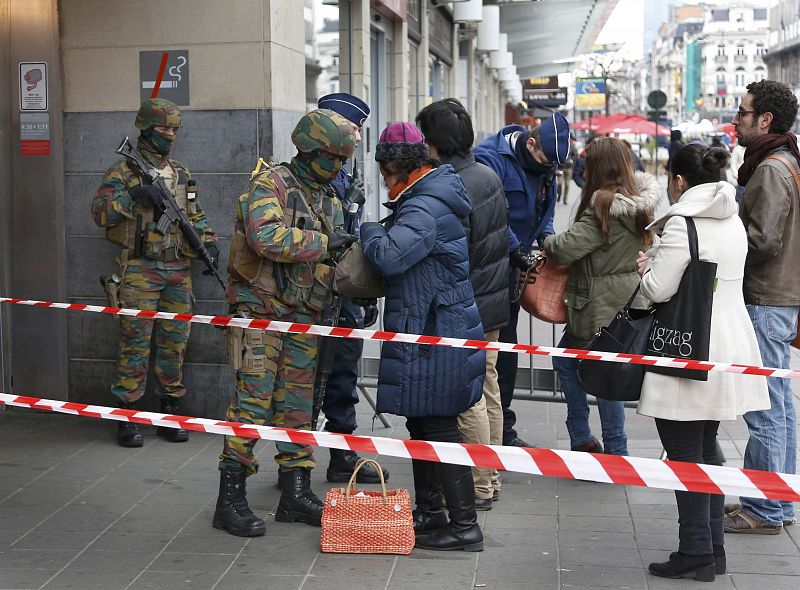 Miembros del Ejército belga registran a los ciudadanos antes de entrar en el metro de Bruselas.