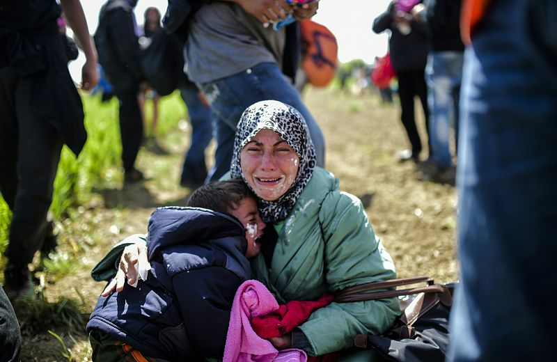 Una mujer y su hijo, desolados tras ser atacados con gas lacrimógeno en la frontera con Macedonia