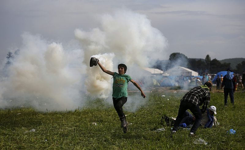 Un niño corre de los gases lacrimógenos lanzados por la guardia de Macedonia