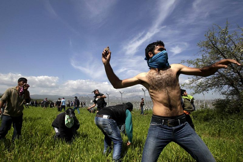 Unos refugiados y migrantes lanzan piedras a la guardia de Macedonia