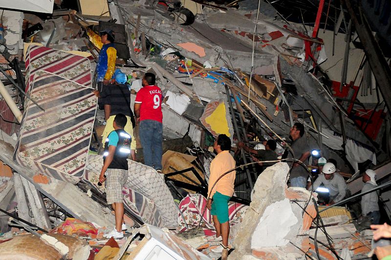 Varias personas junto a uno de los edificios afectados en Manta