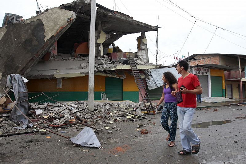 Varios habitantes caminan entre los edificios detruidos en Pedernales