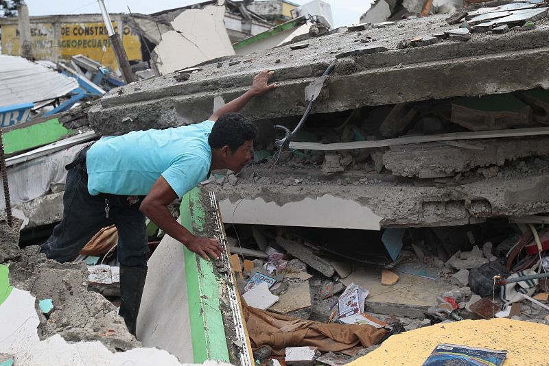 Un habitante de Pedernales mira entre los escombros de un edificio destruido