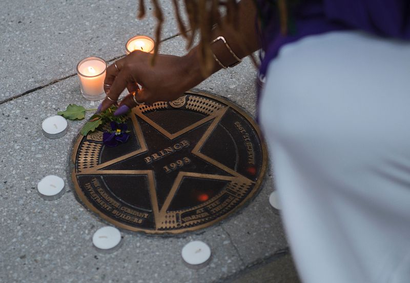 Una mujer enciende velas en recuerdo de Prince en las afueras del Teatro Warner en Washington