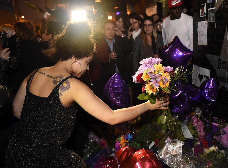 Una multitud coloca flores, mensajes y velas en honor a Prince a las puertas del club nocturno 'First Avenue'