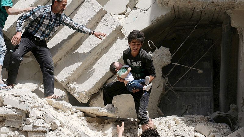 Evacúan a un bebé de un edificio destruido en el barrio de Kalasa, controlado por la oposición. La ONU ha pedido que se mantenga el alto el fuego. AFP PHOTO / AMEER ALHALBI