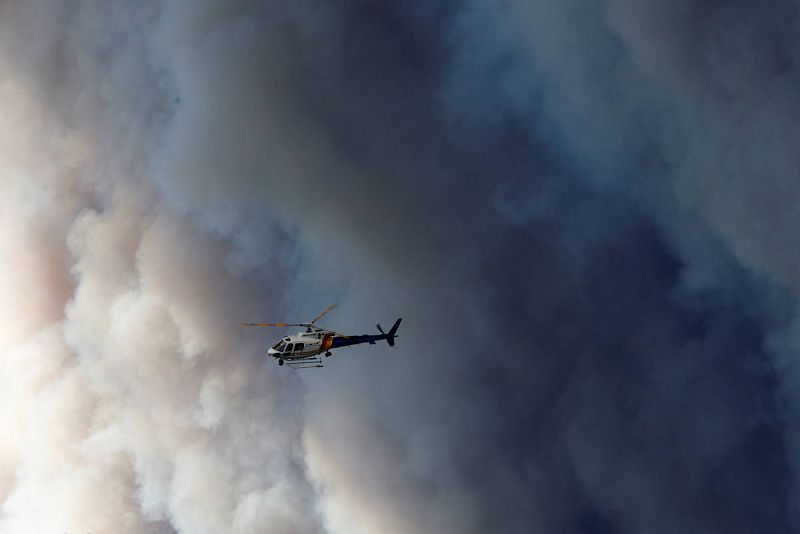 Un helicóptero sobrevuela Fort McMurray cerca de la gran humareda