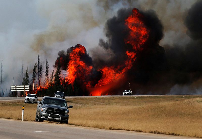 Grandes llamas tras los coches en una carretera cerca de Fort McMurray