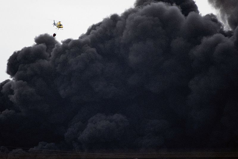 Un helicóptero de los servicios de emergencias trabajan en la extinción del incendio