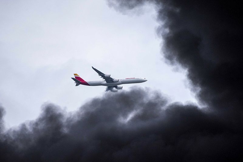 Un avión sobrevuela la humareda provocada por el incendio