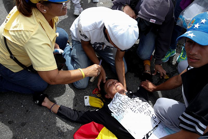 Una mujer herida es atendida por otros manifestantes