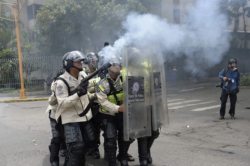 Agentes de la Policía Nacional Bolivariana disparan gases lacrimógenos para disolver la manifestación en contra del presidente Maduro