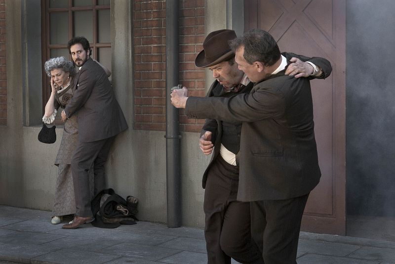 Dos hombres heridos y armados salen de la fábrica ante la mirada de Cristóbal