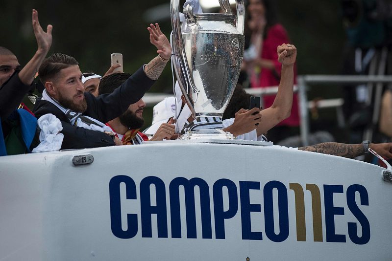 Los jugadores saludan a los aficionados desde el autobús camino de Cibeles