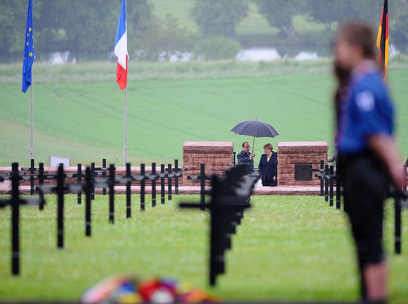 Hollande y Merkel pasean bajo un paraguas por el cementerio alemán de Consenvoye, en el noreste de Francia