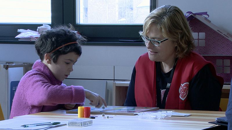 Chloe juega al parchis con una voluntaria de Menudos Corazones