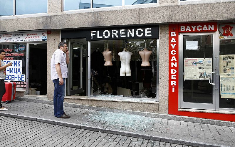 Un hombre inspecciona los daños frente a una tienda tras el atentado en Estambul