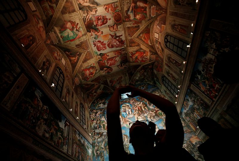 A visitor takes a picture with her cellphone at a full-size replica of the Sistine Chapel after the opening ceremony in Mexico City