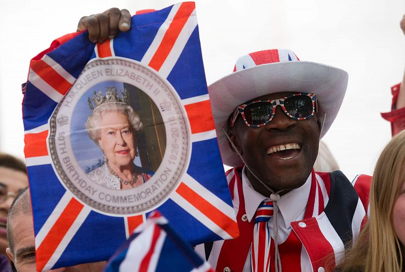 Un seguidor de Isabel II lleva una bandera con la imagen de la reina en la celebración de su 90 cumpleaños