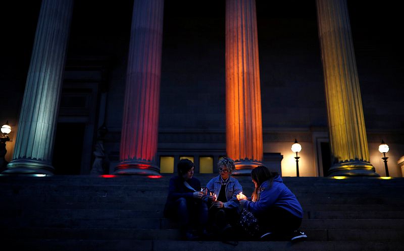 Varias personas portan velas durante la vigilia celebrada en Liverpool (Reino Unido) en memoria de las víctimas del club gay Pulse.