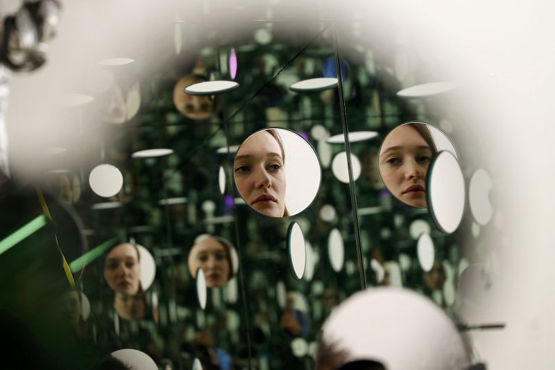 Una empleada del museo posa con Mirror and glass" de Yayoi Kusama