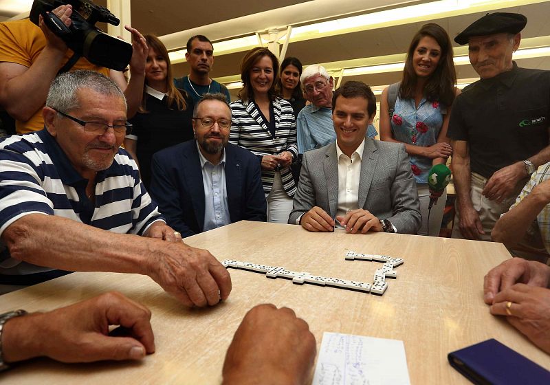 El candidato de Ciudadanos a la Moncloa, acompañado del cabeza de lista por Barcelona, Juan Carlos Girauta, juega una partida de dominó durante su visita al Casal de Gent Gran Can Saladrigas en Barcelona.