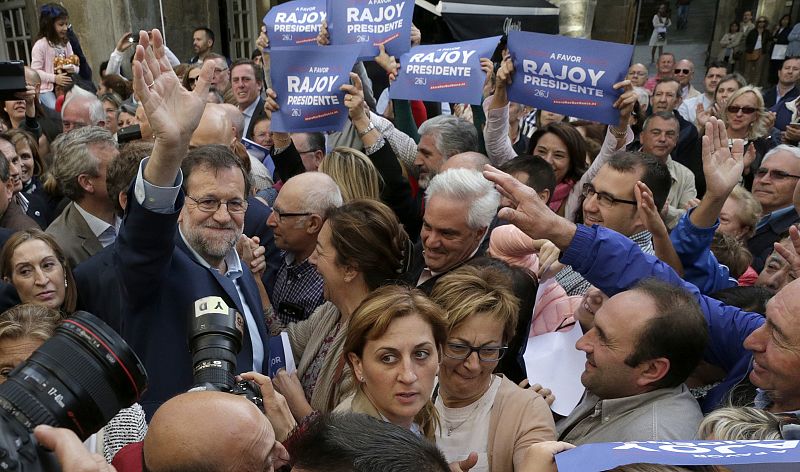 El presidente del Gobierno en funciones y candidato por el PP a la reelección, Mariano Rajoy, saluda a los simpatizantes que le aclamaban a la entrada del teatro donde celebra un acto político, en Pontevedra.
