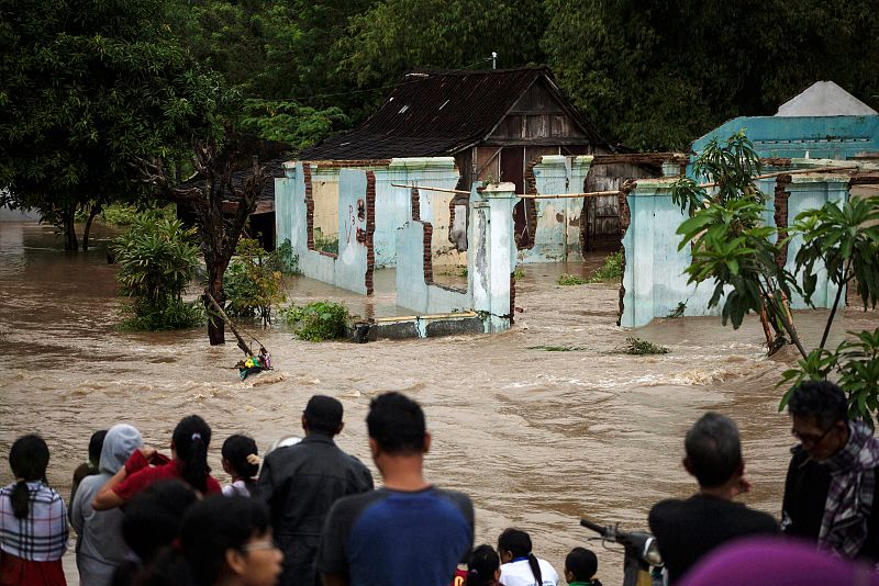 Varias personas observan un área inundada en Kampung Sewuresidential, en la provincia de Java