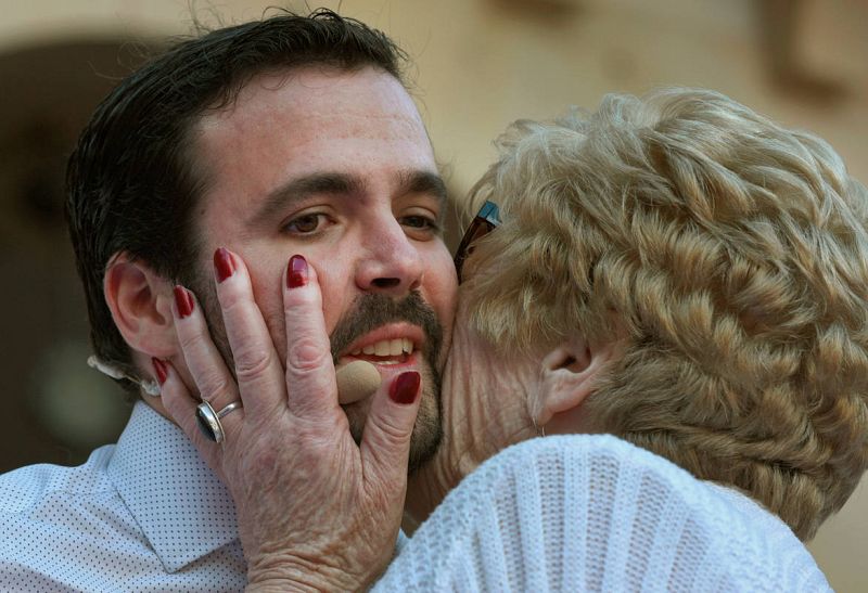 El candidato número cinco de Unidos Podemos al Congreso, Alberto Garzón, recibe el cariño de una simpatizante en un acto de la coalición electoral. 