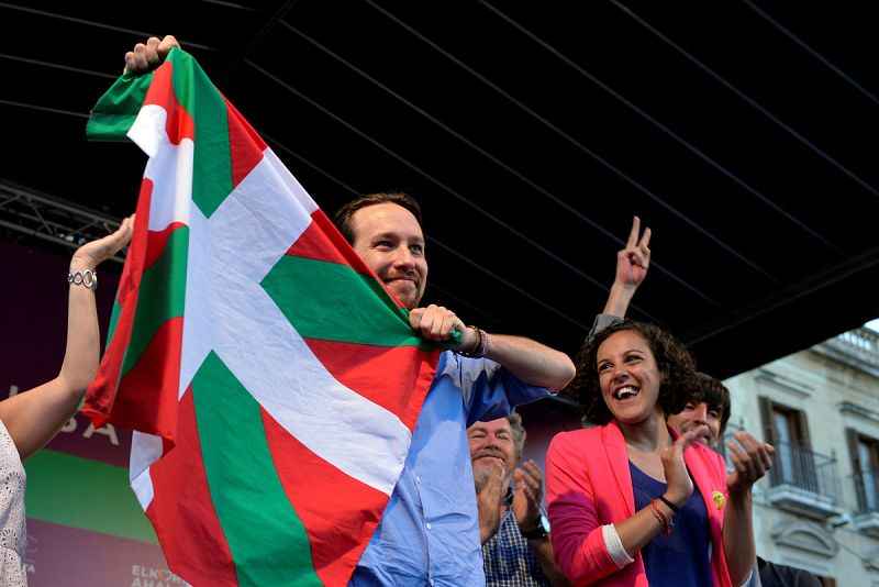 El candidato de Podemos a la Presidencia del Gobierno, Pablo Iglesias, saca una ikurriña tras un mitin en el País Vasco.