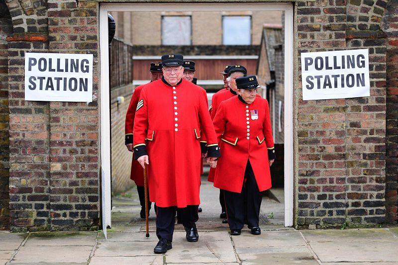 Pensionistas de Chelsea, Londres, abandonan su centro electoral situado en el Royal Hospital tras depositar el voto