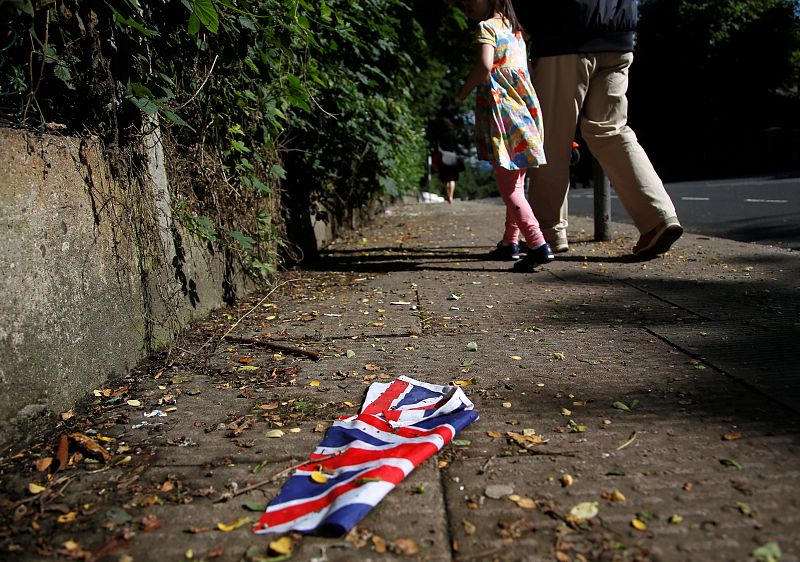 A British flag which was washed away by heavy rains the day before lies on the street in London