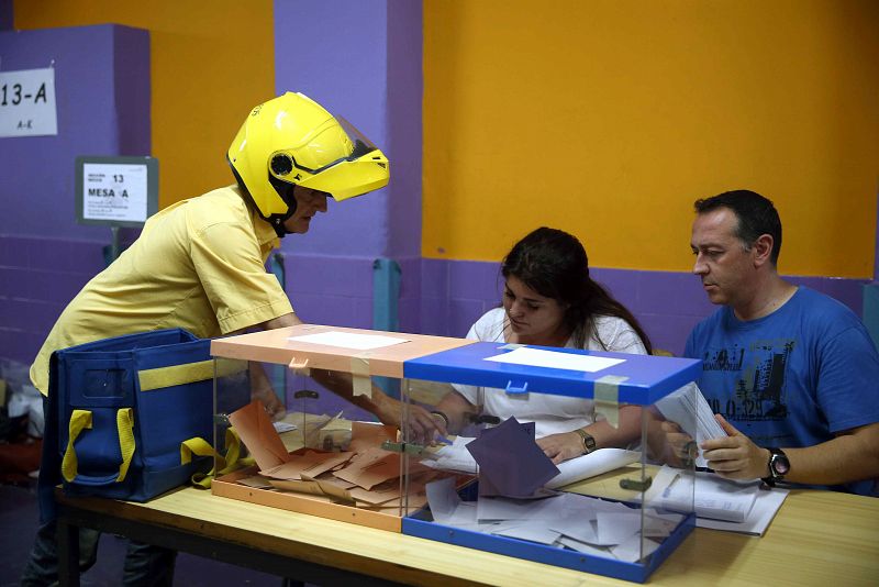 Un cartero entrega el voto por correo en el colegio Santa Marta de l'Hospitalet de Llobregat