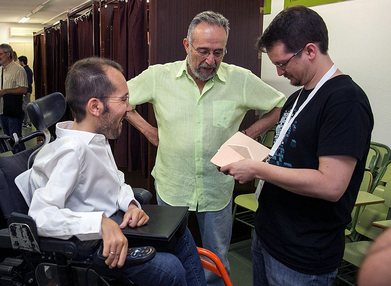 Un apoderado de Unidos Podemos prepara las papeletas con el voto del secretario de Organización de Podemos, Pablo Echenique, en presencia del cabeza de lista al Congreso por Zaragoza, Pedro Arrojo, a la izquierda.