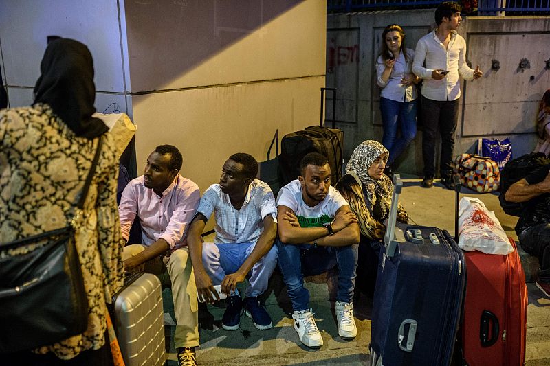 Pasajeros esperan con su equipaje fuera del aeropuerto de Atatürk tras las explosiones y el tiroteo.