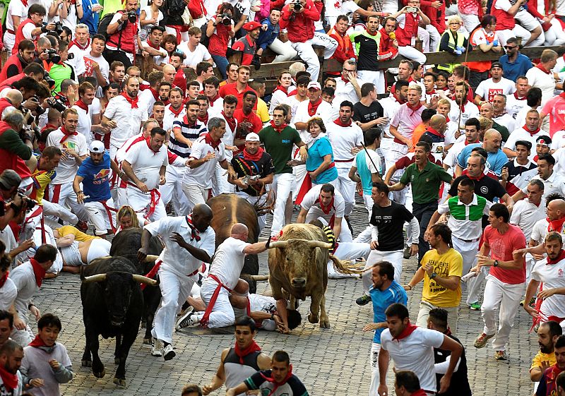 Algunos corredores caen frente a los toros de Fuente Ymbro durante el primer encierro de 2016