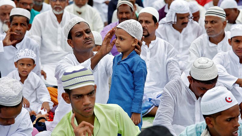 Los musulmanes de todo el mundo continúan celebrando la fiesta de Eid al Fitr, el final del mes de ayuno del Ramadán. En la imagen, un padre prepara a su hijo para las oraciones en Calcuta, India. REUTERS/Rupak De Chowdhuri