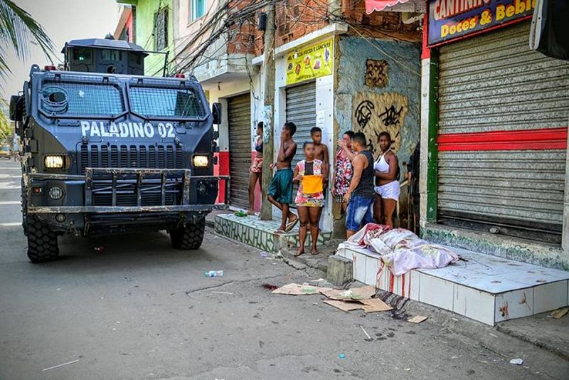 Un blindado de la policía militar circula junto a un cadáver en la favela Jacarezinho en Río