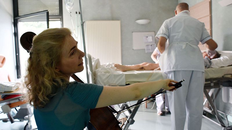 La terapeuta francesa y músico, Claire Oppert, toca el chelo para un paciente en la unidad de cuidados intensivos del Hospital Sainte Perine, en París