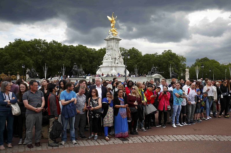 Un montón de curiosos observan en las puertas del palacio de Buckingham