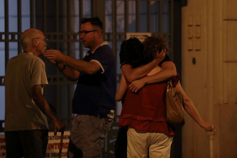 Un grupo de personas se abraza en un portal en Niza tras el atentado perpetrado por un camión