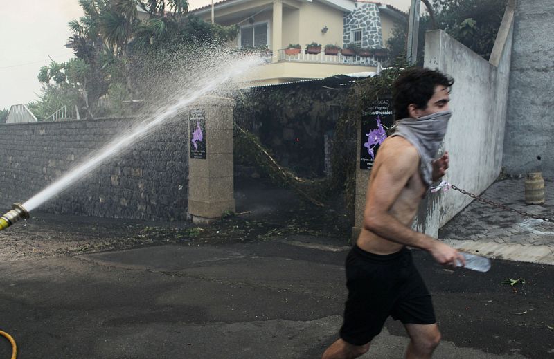 Un hombre corre con la cara cubierta en el incendio