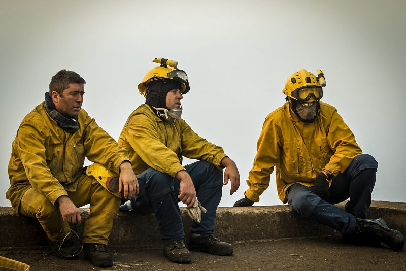 Varios bomberos descansan durante el incendio en Funchal