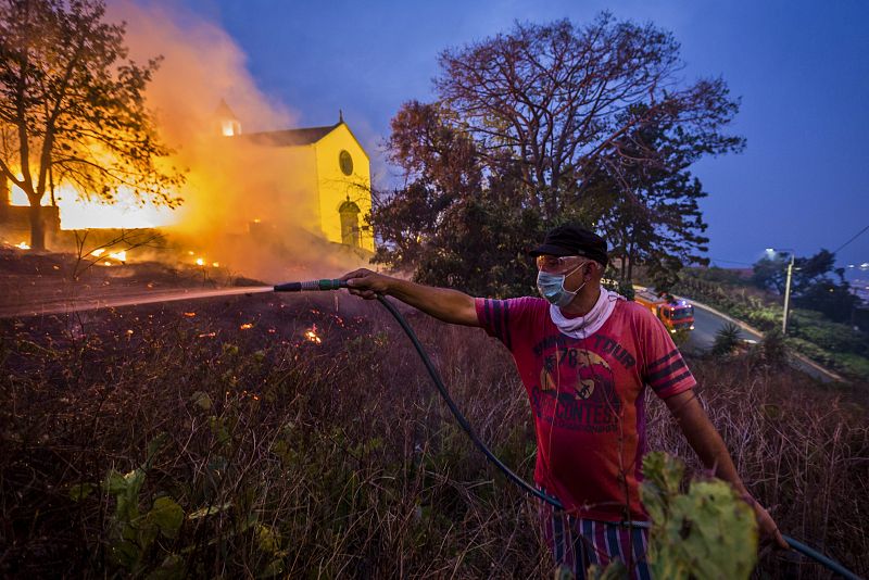 Un vecino ayuda a apagar las llamas con la manguera de su jardín